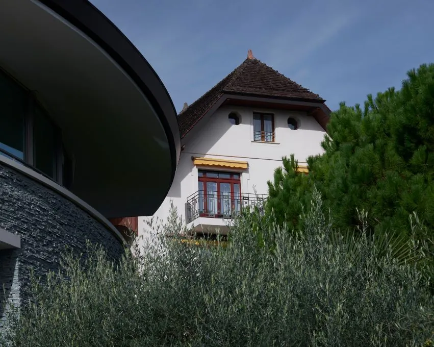 Clinique La Prairie en Montreux: una villa histórica junto a un ala moderna curva, entre olivos y pinos